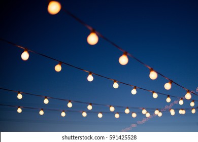 Lights hang overhead on a clear summer night - Shutterstock ID 591425528
