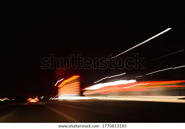 lights from headlights of cars\
and lights from the street lamps draw a colored track in the\
dark