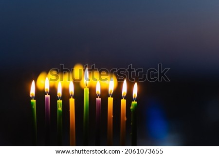 lights the menorah for Hanukkah at sunset sky.  Jewish holiday. Tradition is a religion ritual. The first star. Judaism. background banner. burning holy candle 