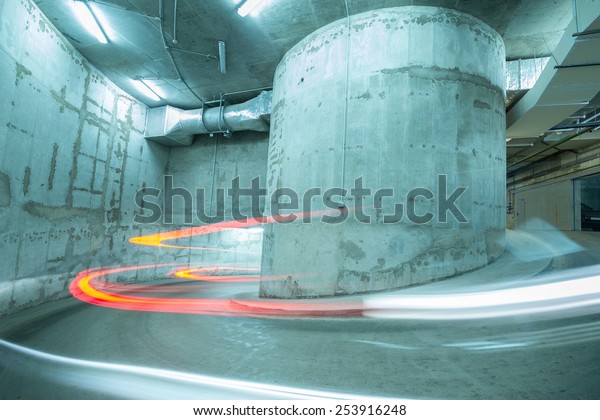 Lights of the moving car above the spiral road\
to the underground\
parking.