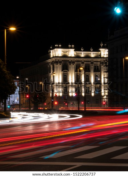 Lights of moving Cars passing by infront of a\
Palace in Vienna at\
Night