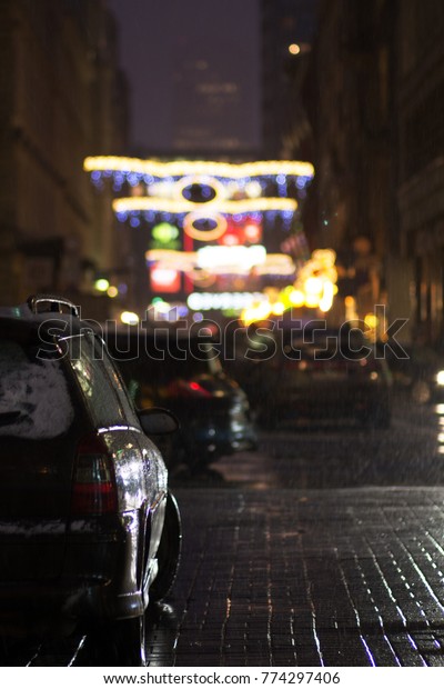 lights of the night city - fuzzy lights\
of cars, lanterns and neon lights during\
snowfall