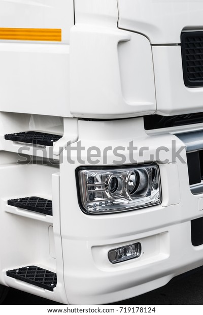 lights and part\
of the cabin of the white\
truck