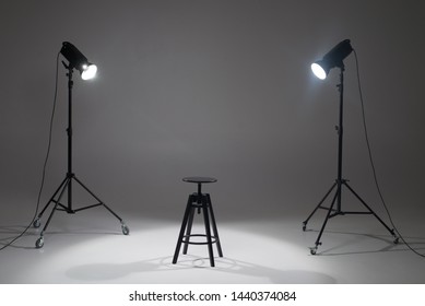 Lights In A Photo Studio On A White Background Are Aimed At A Black Director's Chair