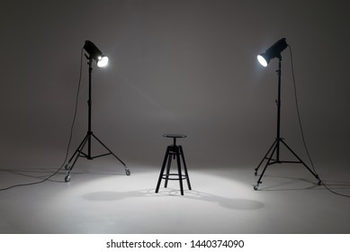 Lights In A Photo Studio On A White Background Are Aimed At A Black Wooden Chair