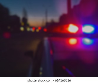 Lights of police car in night time. Night patrolling the city. Abstract blurry image.