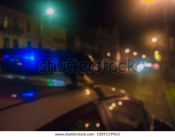 Lights of police car in\
night time. Night patrolling the city, crime scene. Abstract blurry\
image.