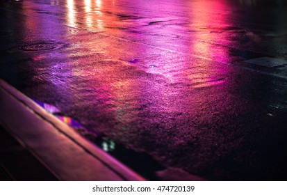 Lights and shadows of New York City. Abstract blurred image of NYC streets after rain with reflections on wet asphalt