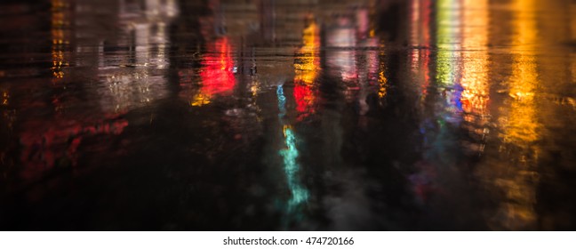 Lights and shadows of New York City. Abstract blurred image of NYC streets after rain with reflections on wet asphalt