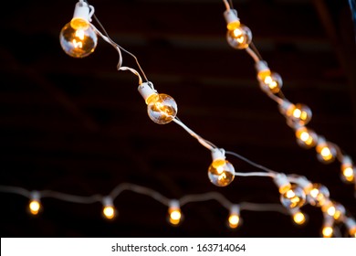Lights Are Strung Up And Hung For This Outdoor Night Time Wedding Reception.