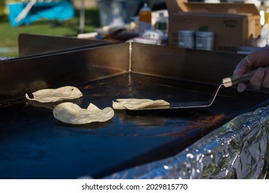 A Light-skinned Hand In A Food Prep Glove, Flipping Tortillas On A Hot Griddle