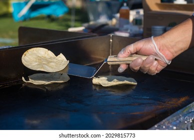 A Light-skinned Hand In A Food Prep Glove, Flipping Tortillas On A Hot Griddle