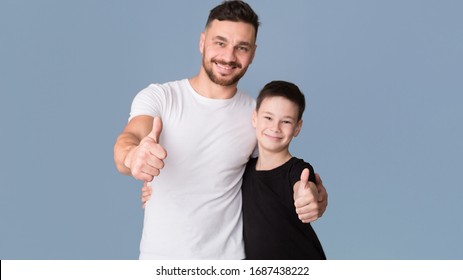 Like. Dad and son showing thumb up gesture, grey studio background - Powered by Shutterstock