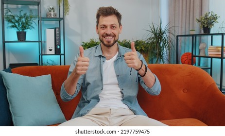 Like. Happy Handsome Adult Man Looking Approvingly At Camera Showing Thumbs Up, Like Sign Positive Something, Good News, Positive Feedback. Young Guy Sitting On Orange Couch At Home Living Room