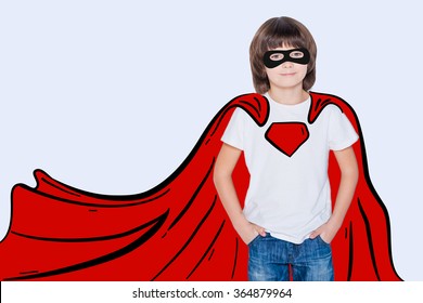 Like hero  Cheerful boy holding hands in pockets   looking like superhero in his drawn cape while standing against white background