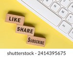 Like Share Subscribe words on wooden blocks with keyboard. Social media marketing concept background.