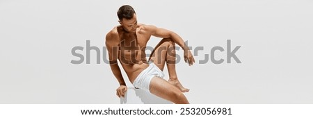 Like a statue. Handsome man posing shirtless on cube, showing his perfect muscular body isolated on white studio background. Concept of male beauty, body and skin care, health, sport