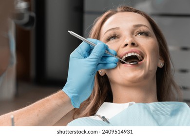 Like a true expert, the doctor examines each tooth in detail, assessing the condition of the enamel, gums, and other aspects of dental health. The doctor skillfully uses dental instruments, providing - Powered by Shutterstock