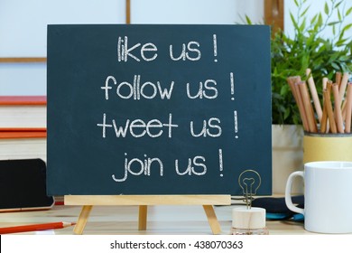 Like Us Follow Us Tweet Us Join Us- Message Text On A Blackboard With Pencils Coffee Cup And Mobile Phone. The Concept Of Social Media Marketing And Management