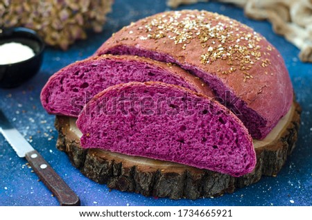 Lilac bread on a board with sesame seed  