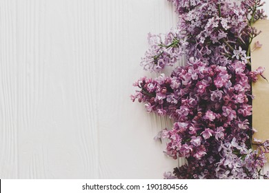 Lilac Flowers Blooming From Craft Envelope Flat Lay On White Wood With Space For Text. Flower Delivery And Hello Spring. Happy Mothers Day And Womens Day. Creative Floral Greeting Card