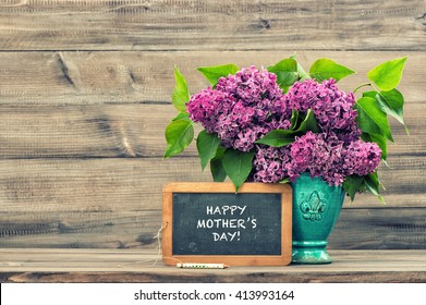 Lilac flowers and vintage blackboard with sample text Happy Mothers Day! Vintage style toned picture. Mother's Day greetings card. Vintage still life. Mother's day. Mothers Day gift. Mothers Day - Powered by Shutterstock