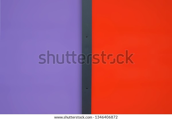 Lilac and red metallic\
background in vertical divided by a black strip of the facade of a\
building