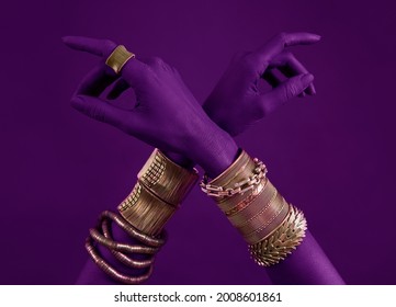 Lilac woman's hands with gold jewelry. Oriental Bracelets on a Lilac neon painted hand. Gold Jewelry and luxury accessories on Purple background closeup. High Fashion art concept  - Shutterstock ID 2008601861