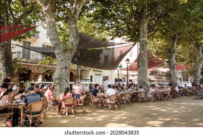 L'Ile Rousse, Corsica, France - 19th August 2021: Holidaymakers relax outside the Café des Platanes at L'ile Rousse in the Balagne region of Corsica