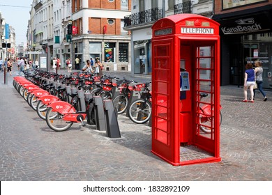 LILLE, FRANCE - July 18, 2013. Red British Telephone Box And Free Bike Rental Station In A Street In Lille, France