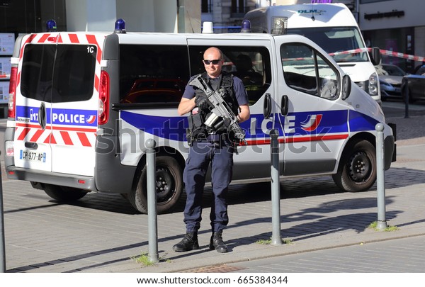 Lille, France - May 26, 2017: Police officer\
with a gun at a roadblock during bomb threat in a street in the\
center of Lille, France on May 26,\
2017