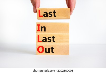 LILO last in and out symbol. Concept words LILO last in last out on wooden blocks. Beautiful white table white background. Businessman hand. Business and LILO last in and out concept. Copy space.