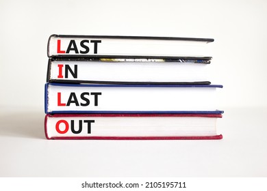 LILO last in out symbol. Concept words LILO last in last out on books. Beautiful white table, white background. Businessman hand. Business and LILO last in and out concept. Copy space.