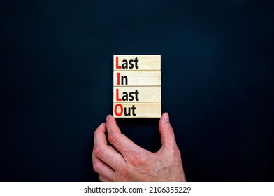 LILO last in out symbol. Concept words LILO last in last out on wooden blocks. Beautiful black table black background. Businessman hand. Business and LILO last in and out concept. Copy space.