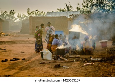 Lilongwe/ - August 13 2018: women gather around huge pots boiling water in a Malawian village as the sun sets