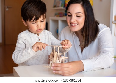 Liltle Preschooler Kid Playing With Wood 3d Puzzle And Teacher Educador Help. Homeshooling. Learning Community. Montessori School

