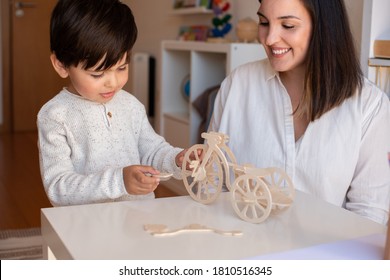 Liltle Preschooler Kid Playing With Wood 3d Puzzle And Teacher Educador Help. Homeshooling. Learning Community. Montessori School

