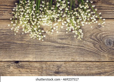 Lily of the valley on the old wooden background. Place for text. Top view.