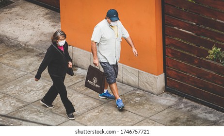 Lima Peru; 05 22 2020: Older Woman Walking With Man In Mask At Quarantine For Virus Crown In Lima Peru