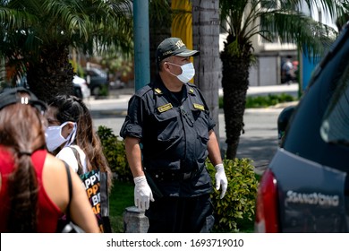 Lima, Peru - April 4 2020: Policeman Wearing A Face Mask And Gloves Amid Coronavirus Outbreak In South America. Officer Patrolling The Streets At COVID-19 Times.