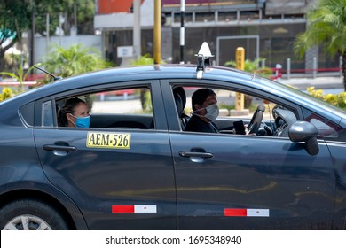 Lima, Peru - April 4 2020: Taxi driver and passenger wearing mask amid coronavirus outbreak in South America. 