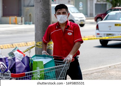 Lima, Peru - April 4 2020: Wong Supermarket Worker Wearing A Mask Amid Coronavirus Outbreak In South America. Organizing Shopping Carts Outside A Store In COVID-19 Times.