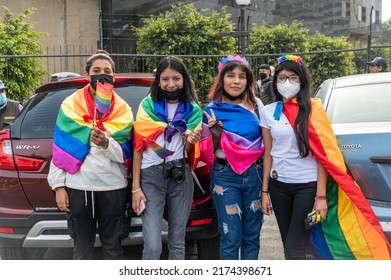 LIMA, PERU - JUNE 25, 2022: Photo Of A Group Of Young Latinx People Posing With Rainbow And Bisexual Flag Capes At Lima's Marcha Del Orgullo, The City's Annual Pride March Event.