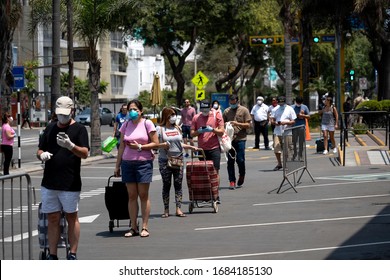 Lima, Peru - March 26 2020: People lining in a queue practicing social distancing amid coronavirus outbreak in South America. Hispanic customers lined up to buy groceries in the supermarket.