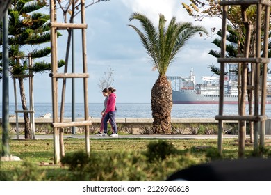 Limassol, Cyprus - February 22, 2019: People Walking At Molos Seaside Park With Offshore Drilling Rig On Background