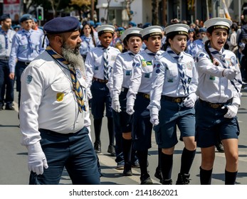 Limassol, Cyprus, March 25th, 2022: Boy And Girl Scout Group With Adult Leader Marching Along Archbishop Makarios III Avenue During The Greek Independence Day Parade