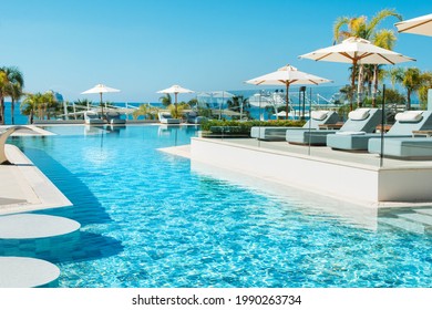 Limassol, Cyprus - May 19, 2021: Pool Area In Luxury Modern Hotel With Sunbeds In The Shade Of Palm Trees And Tropical Plants