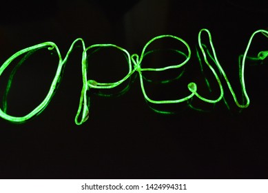 
Lime green lighting with a specific pattern. Woven filaments, cable, wires with outgoing light. Neon electroluminescent wire with an inscription and letters open.