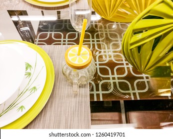 Lime Green Plates, Mason Jar, Lamp And Napkins Sitting On A Glass Table. Very Modern Cutlery For A Contemprory Home. Makes Great Holiday Table Ware