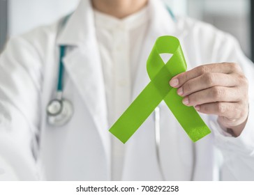 Lime Green Ribbon In Doctor's Hand For Lymphoma Cancer And Mental Health Awareness, Raising Support And Help Patient Living With Illness 